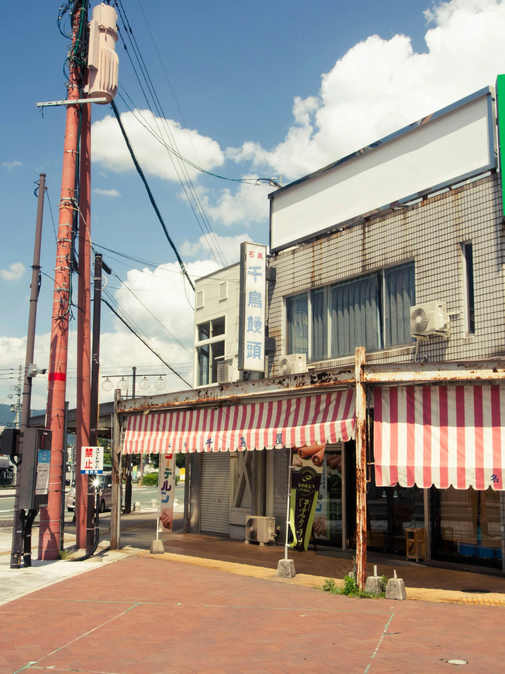 a restaurant has striped awnings on the outside of it