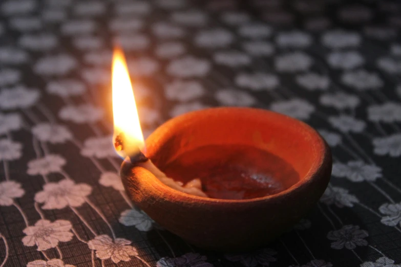 candle being used to light up a wooden bowl