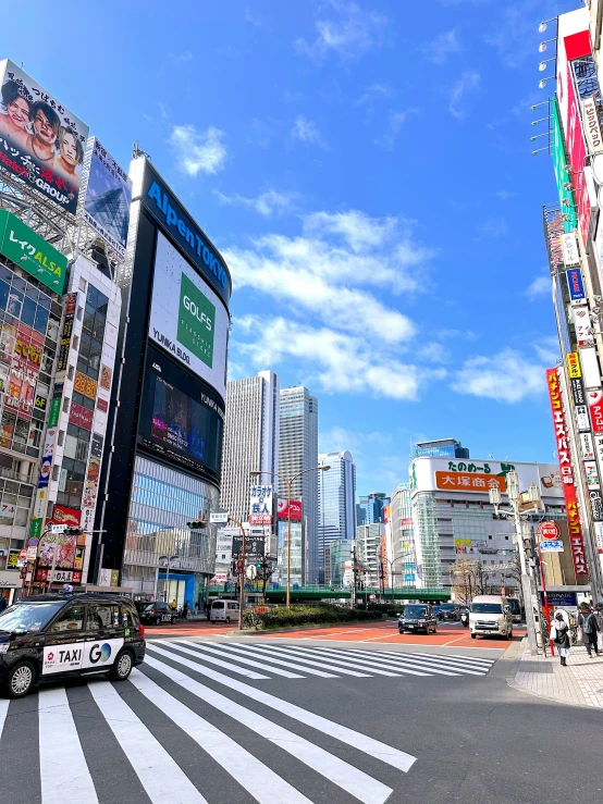 city street intersection with cars, cars, and billboards