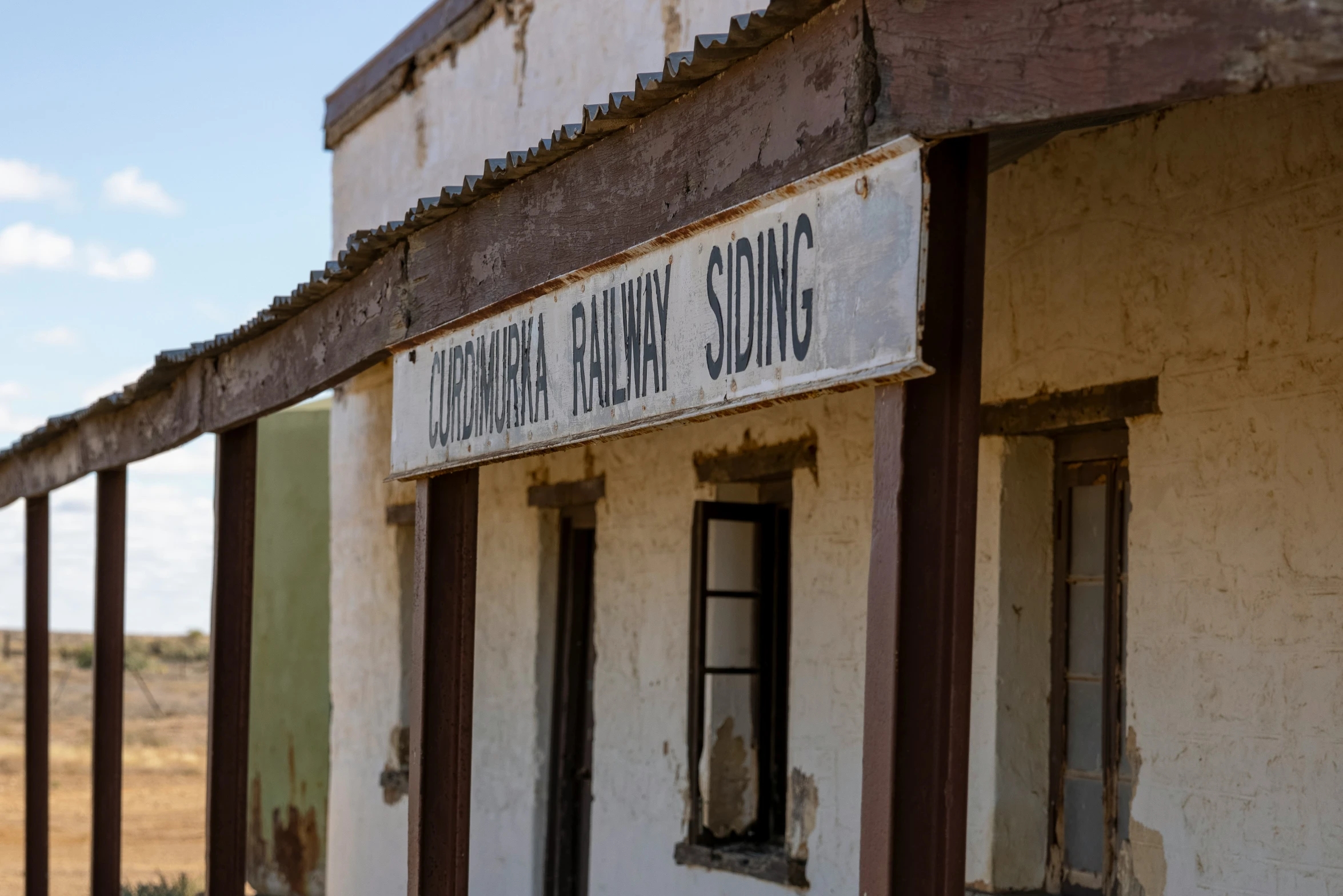 a dilapidated building with an old sign in front of it