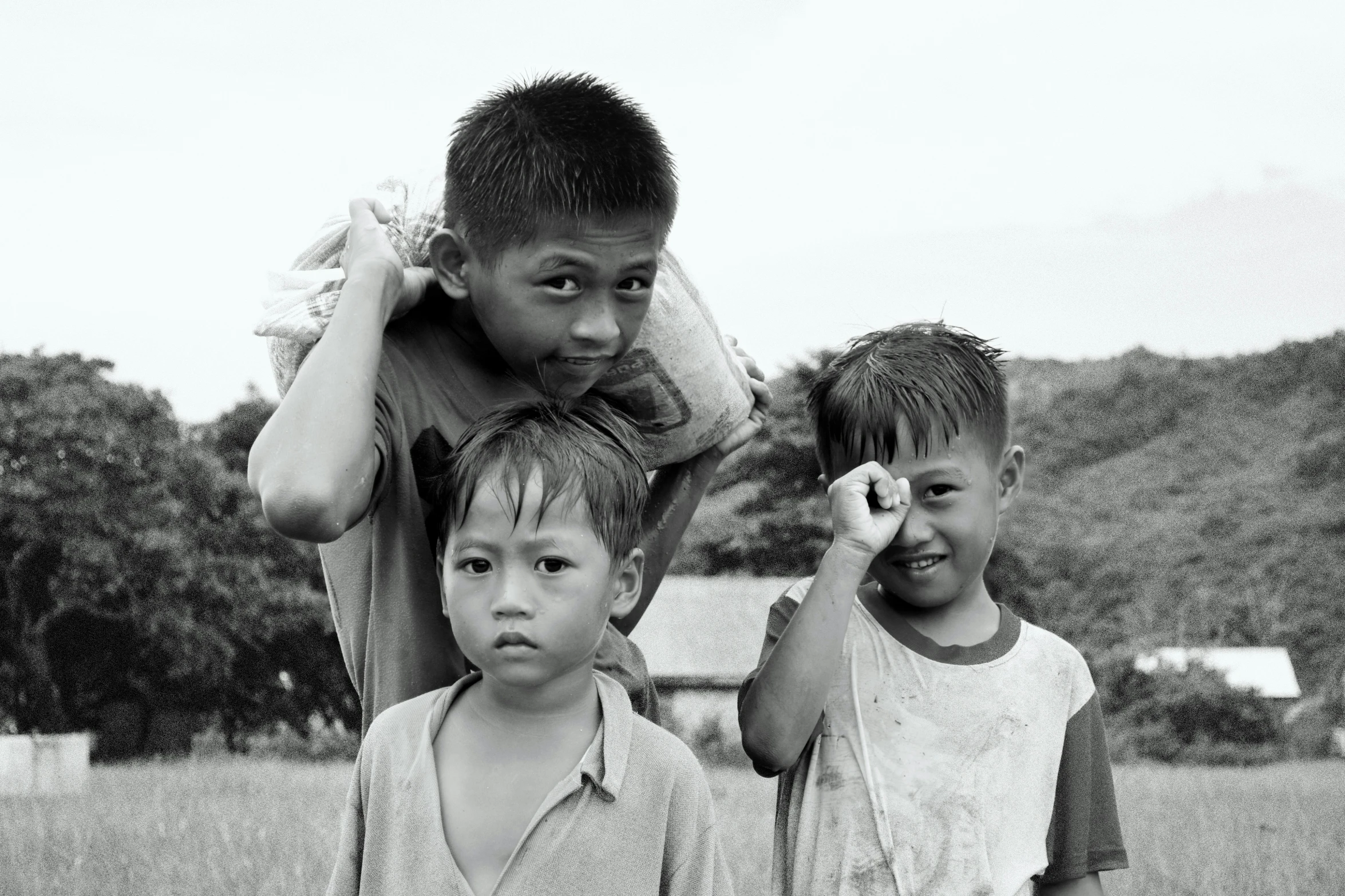 a person is brushing their hair as two boys are looking on