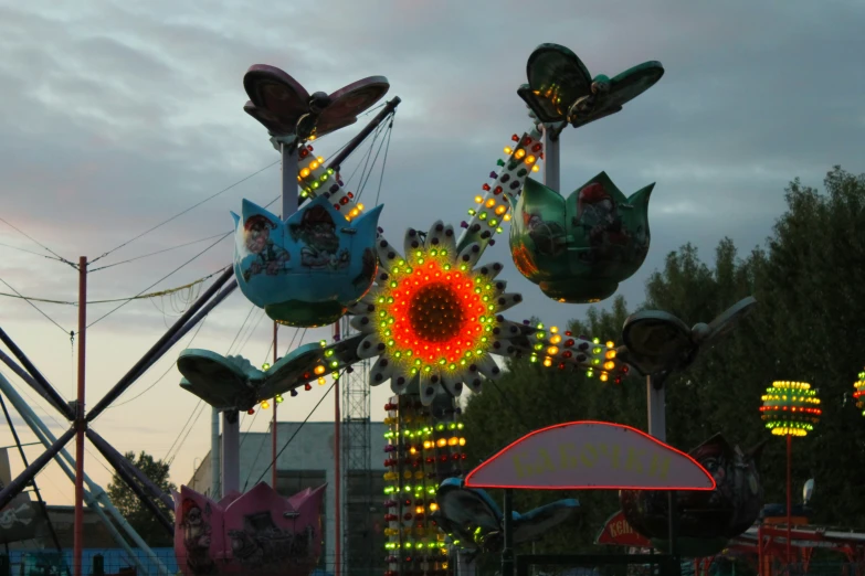 a carnival carnival ride at the fair with several rides illuminated up