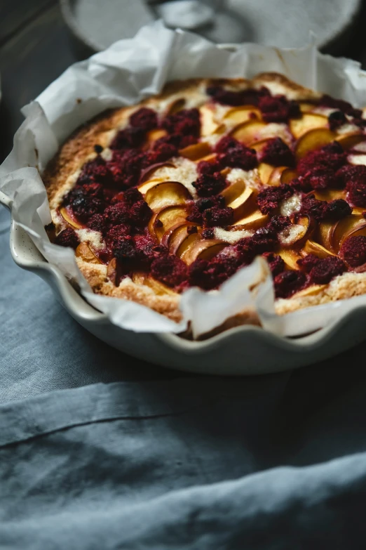 a baked pie is shown with blueberries and apple slices