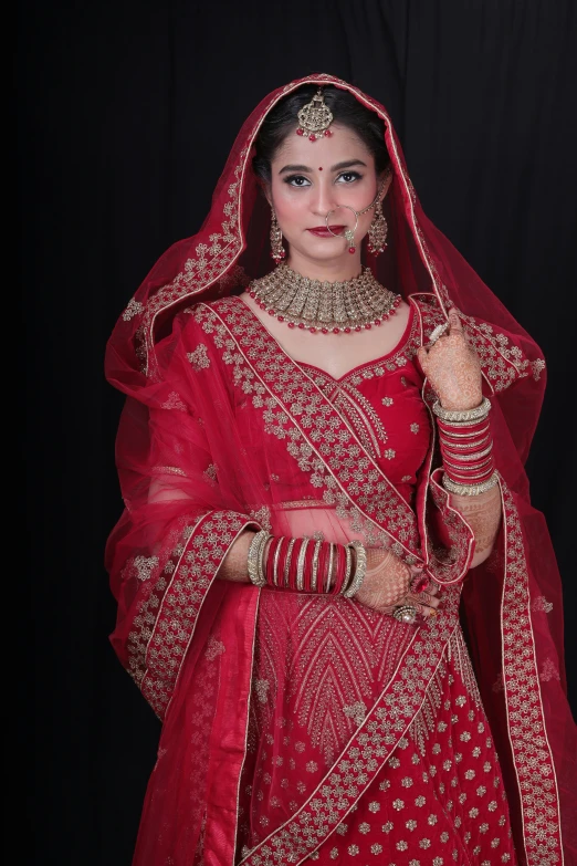 a woman in red indian outfit posing for a po