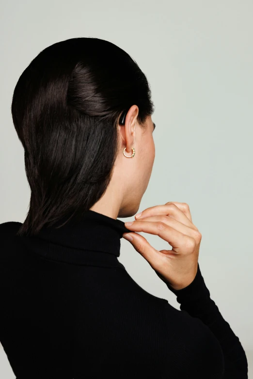 an attractive woman holding her ear with a cross neck