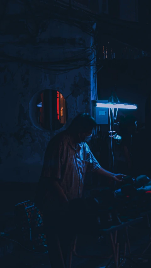 a person sits at a work station in the dark