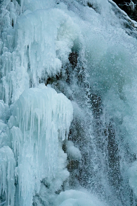 the side of an icy rock with a bunch of icicles on it