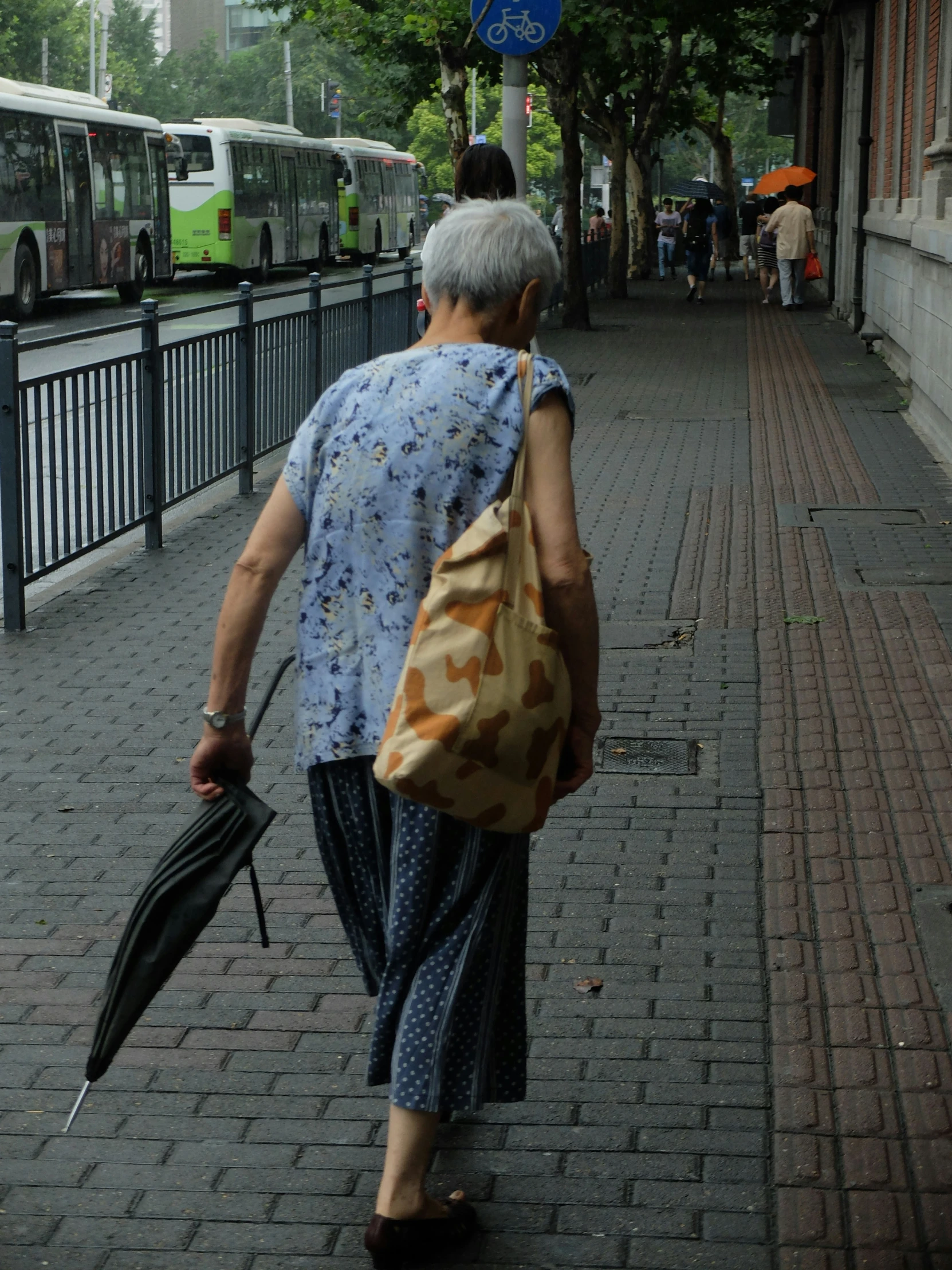 a woman is walking down the street with an umbrella