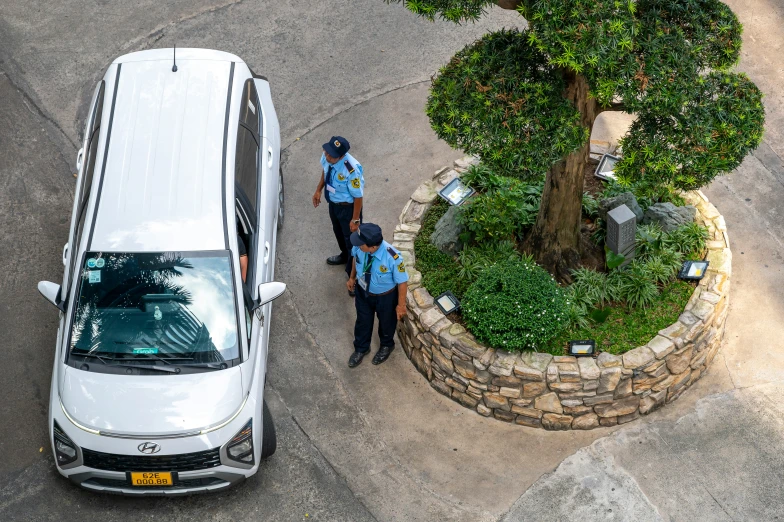 a white van parked next to two men near a tree