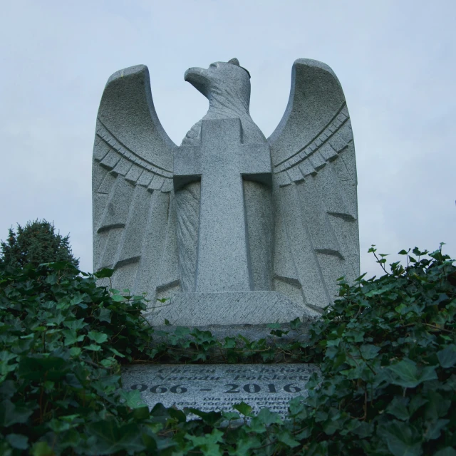 an eagle statue is above the bushes