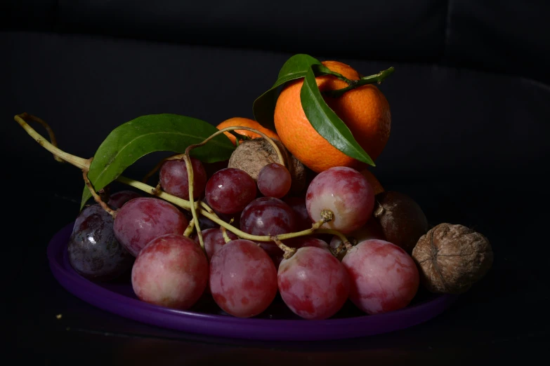 a purple plate with several fruit and vegetables on top