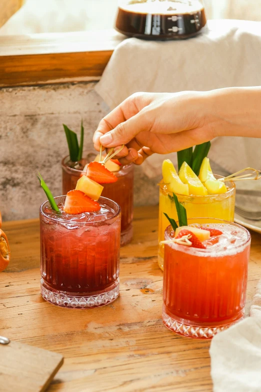 two colorful cocktails are sitting on the table