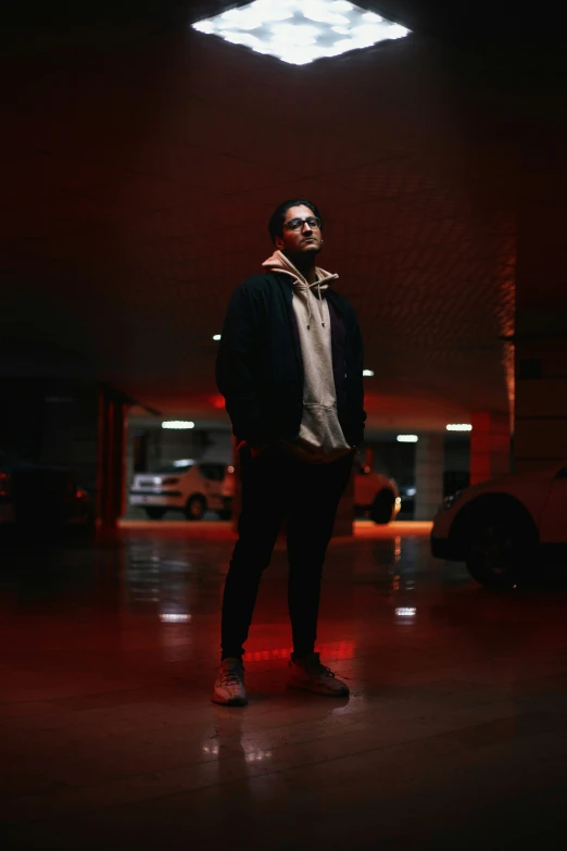 a person standing in a dark room with some cars