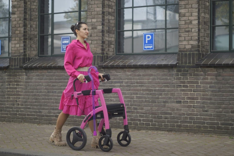 a woman in pink with a walker walking by