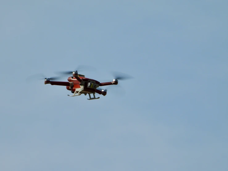 a red helicopter flying through a blue sky