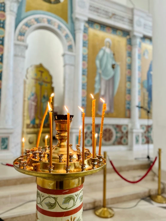 a small gold plate with many candles in it