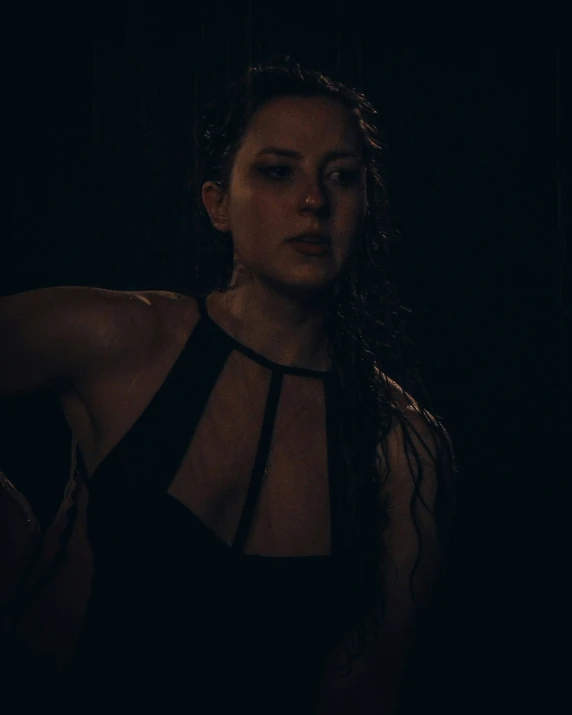 a woman with wet hair is standing in the dark