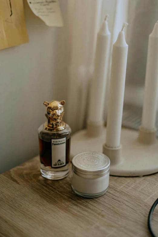 a small glass jar next to an antique perfume bottle