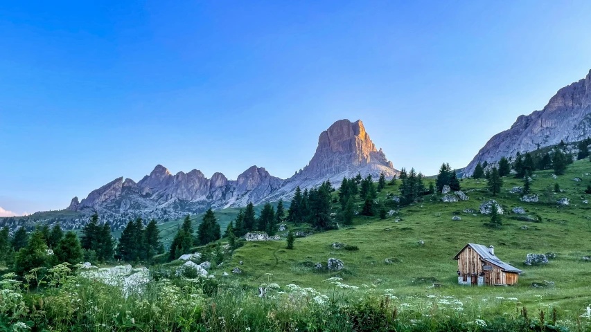 an old mountain with a house in the grass