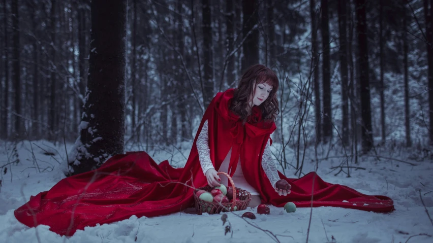 a woman in red sitting on a snow covered ground