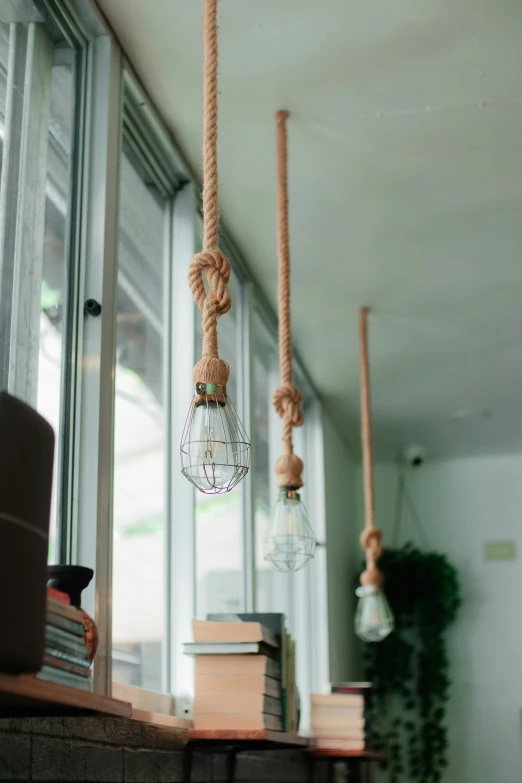 some hanging light bulbs and books on a counter