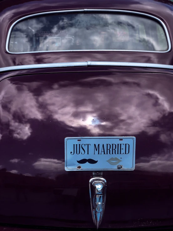 an antique car with just married license plate