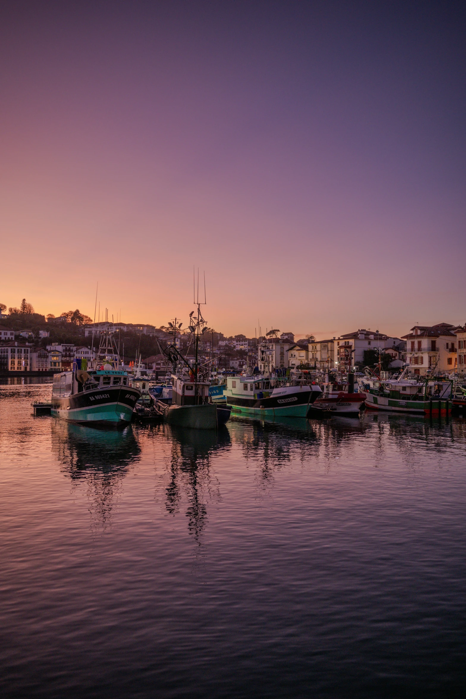 a marina filled with lots of boats next to a city