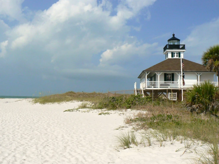 a beach with sand and grass surrounding it