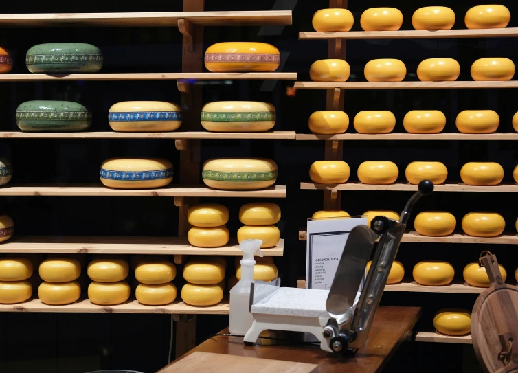 cheeses and cheese cutters are placed on shelves next to each other