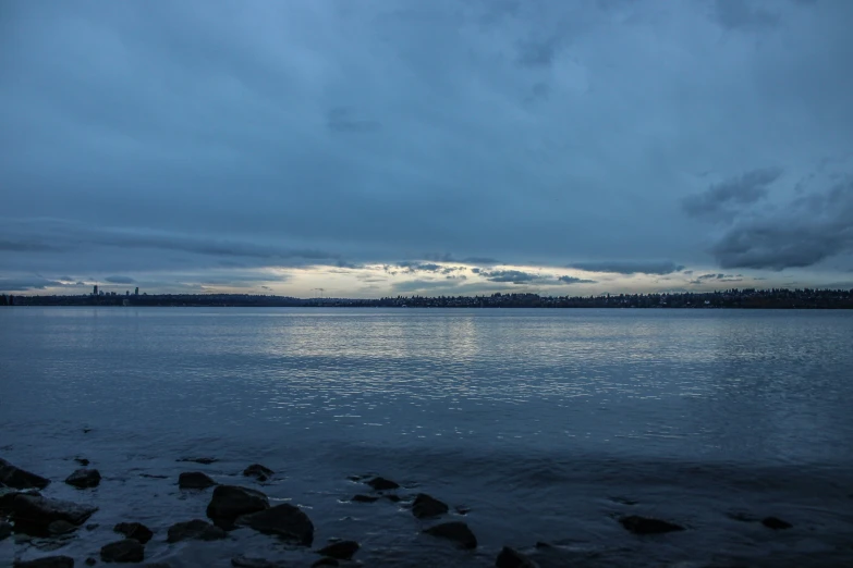 the calm blue water is near rocky shore