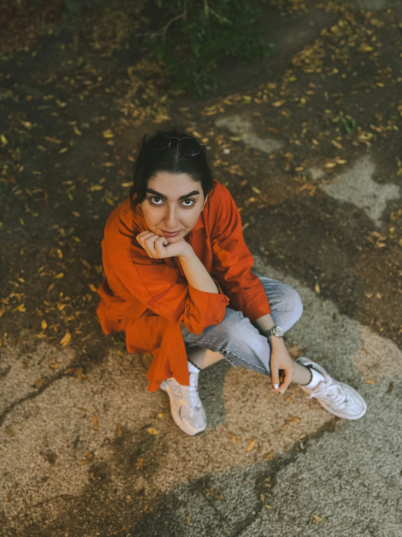 a person sitting on the ground in a red shirt