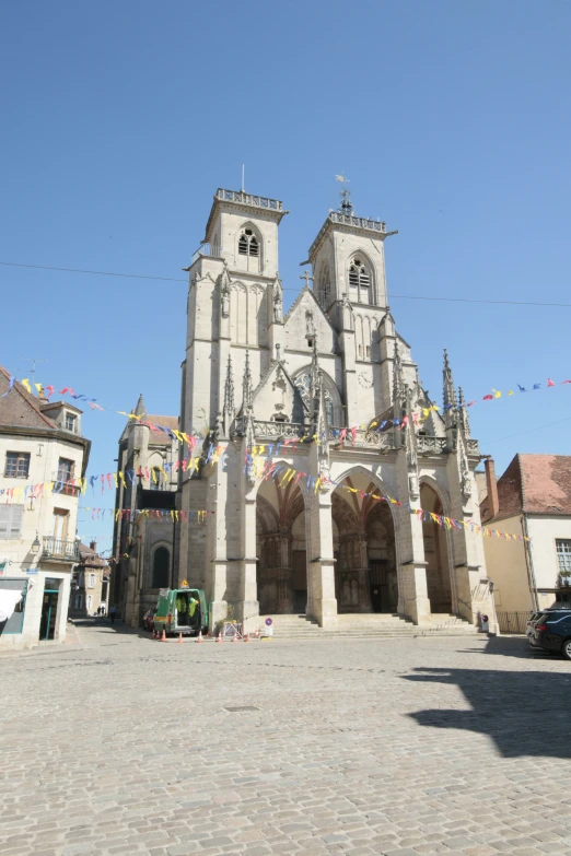 a tall gothic church with flags in front