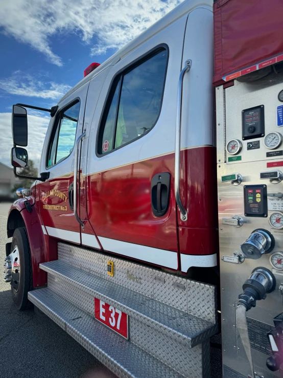 a red and white emergency truck parked near another vehicle