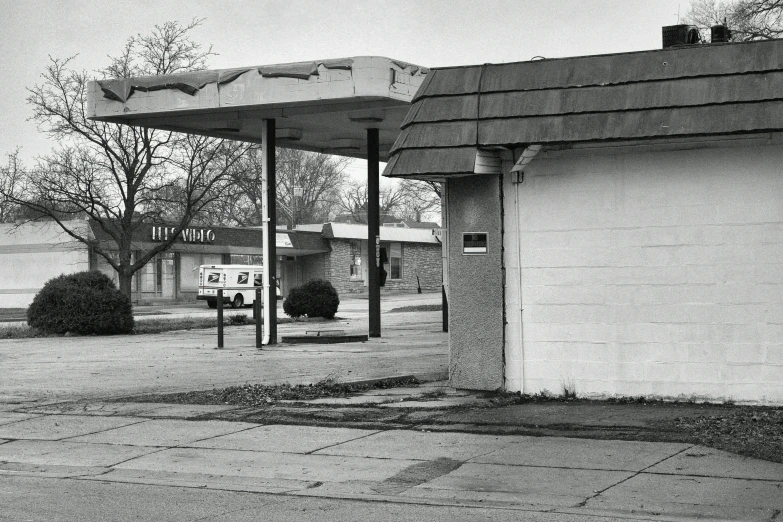 a gas station on a street corner with a sign in front of it