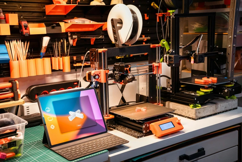 a 3d printer in a shop near a laptop