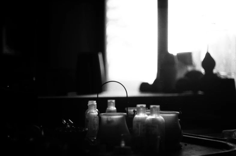 three bottles sitting on a table with one empty