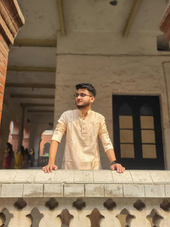 the man stands at a ledge in front of a building