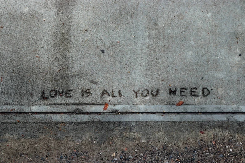 a graffiti sprayed on a wall says'i love all you need '