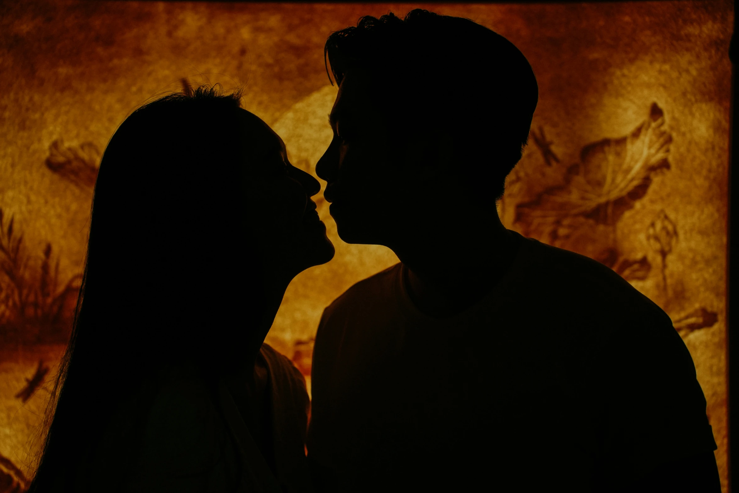 a silhouette of a man and woman facing each other