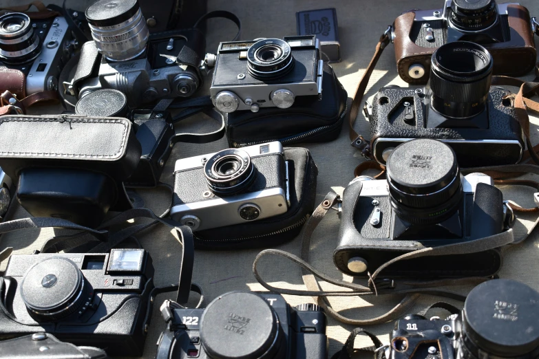 a collection of old fashioned cameras sitting on the floor