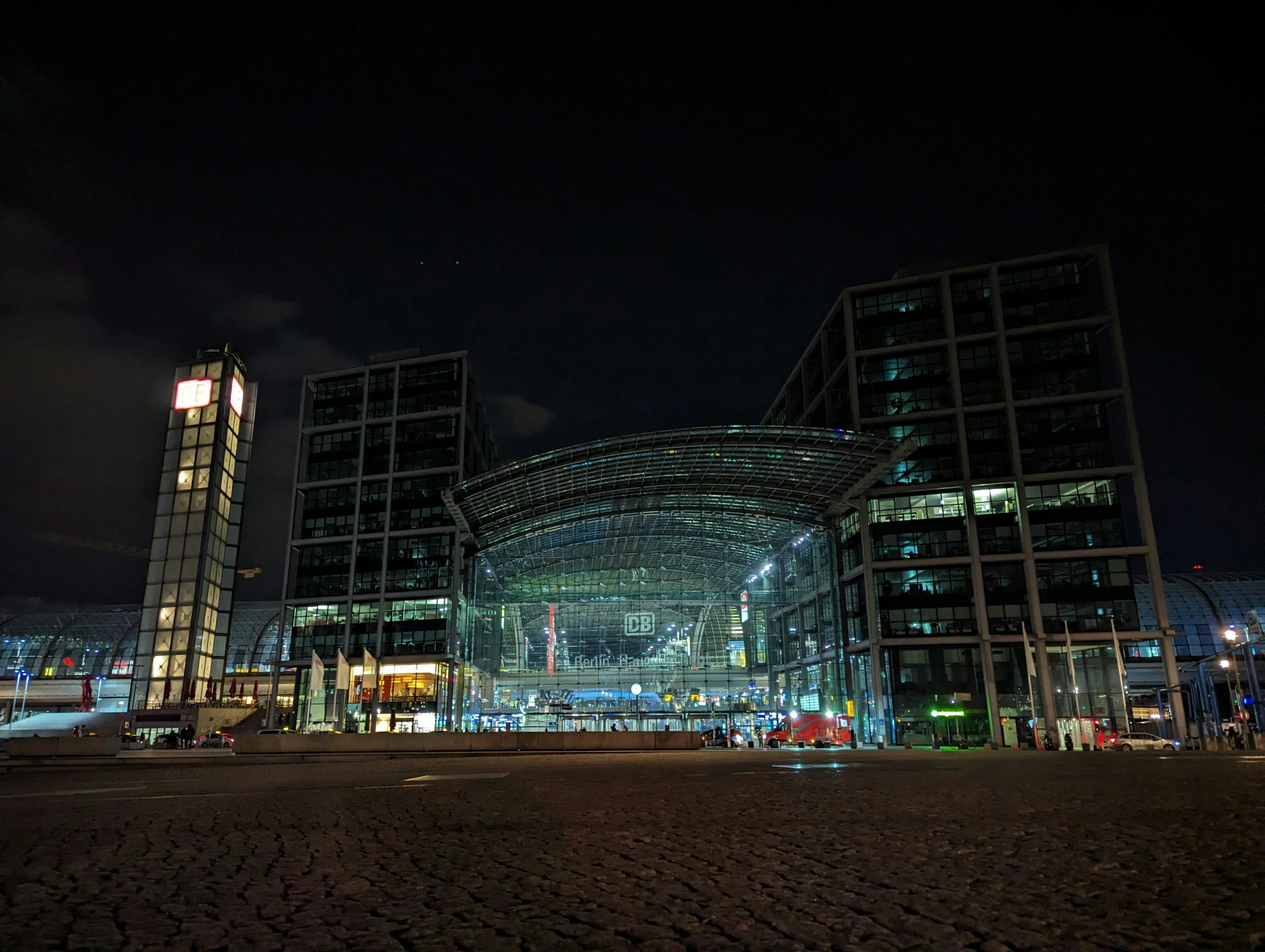 the tall building with glass front is lit up at night