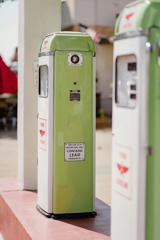 the gas pump is sitting next to the public toilet