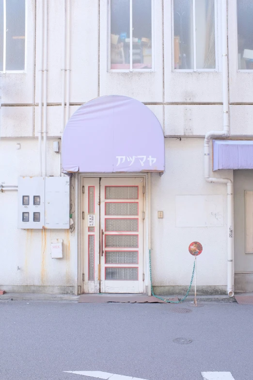 a small door with purple covering stands on a street