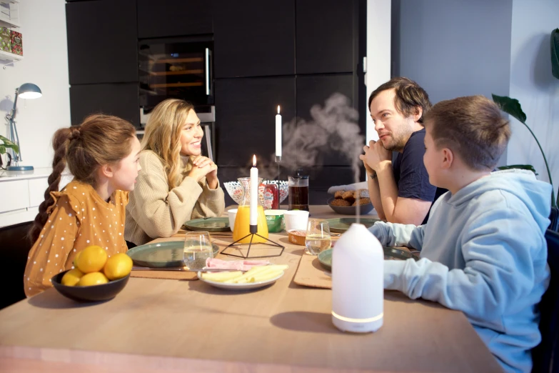 a family eats dinner around the kitchen table