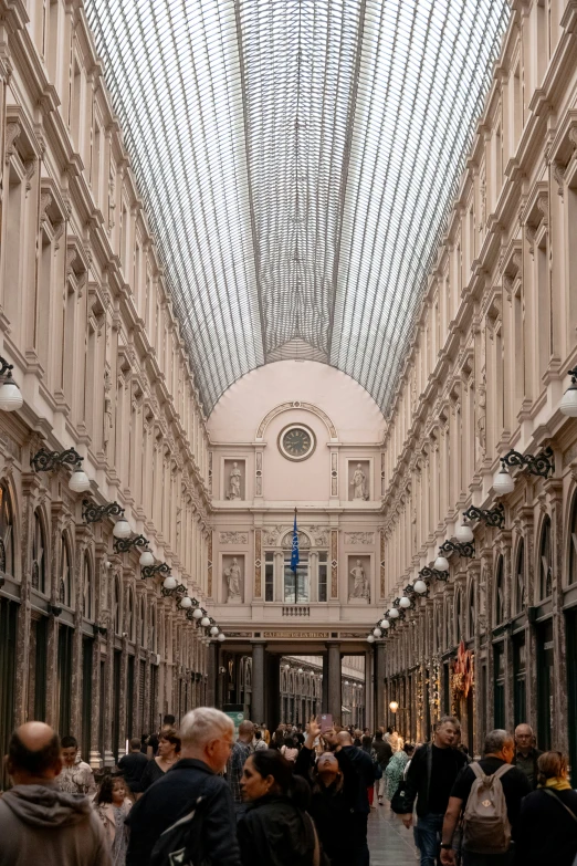 an empty walkway surrounded by white pillars and ceilings