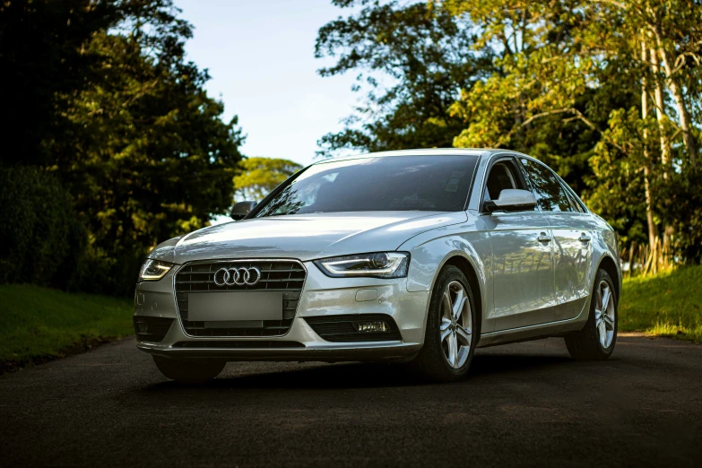 a silver car parked in the middle of a forest