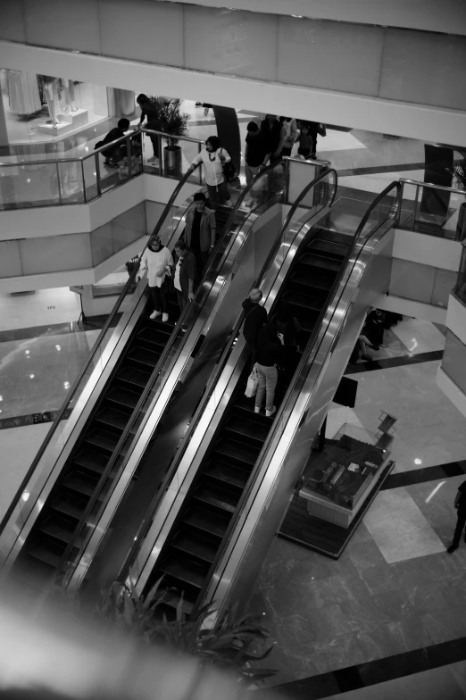 escalators with two people on them on a public walkway