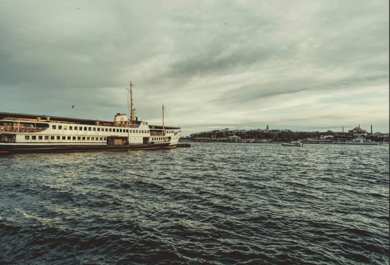 a big boat on the water on a cloudy day