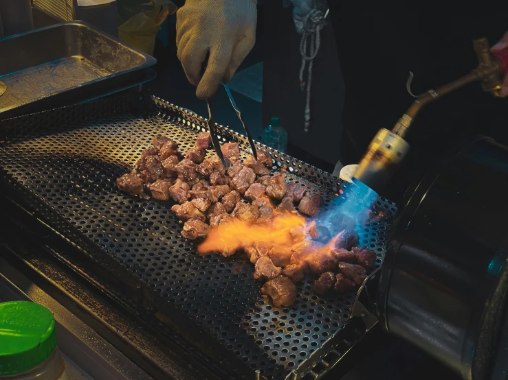 a man cooking meat on top of a grill