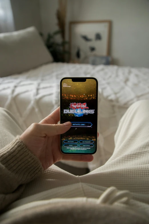 a person is holding their phone in one hand while on a bed